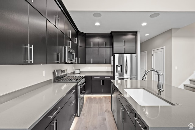 15084 S Wild Horse Way, Bluffdale, UT 84065 - kitchen with recessed lighting, an island with sink, appliances with stainless steel finishes, a sink, and light wood-type flooring