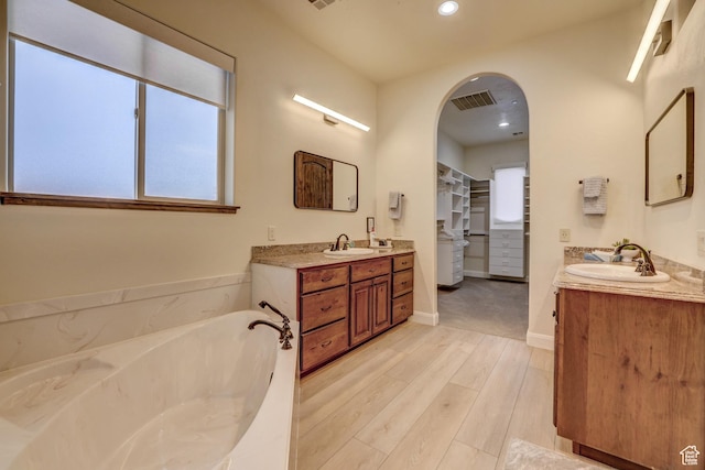 595 W 2050 S, Hurricane, UT 84737 - full bathroom featuring two vanities, wood finished floors, a bath, and a sink