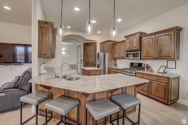 595 W 2050 S, Hurricane, UT 84737 - kitchen with a sink, stainless steel appliances, a breakfast bar, light wood-style flooring, and a peninsula