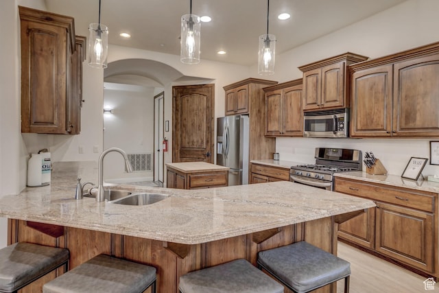 595 W 2050 S, Hurricane, UT 84737 - kitchen featuring a sink, a breakfast bar area, a peninsula, arched walkways, and appliances with stainless steel finishes