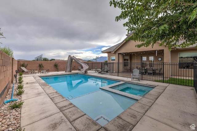 595 W 2050 S, Hurricane, UT 84737 - view of pool featuring a patio, a fenced backyard, a water slide, and a pool with connected hot tub