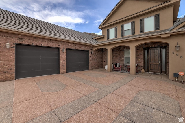 595 W 2050 S, Hurricane, UT 84737 - view of front of house with covered porch, brick siding, stucco siding, and driveway