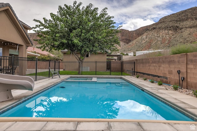 595 W 2050 S, Hurricane, UT 84737 - view of pool featuring a water slide, a mountain view, a fenced backyard, and a pool with connected hot tub