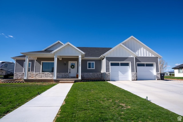 166 W 580 N, Redmond, UT 84652 - view of front of property featuring board and batten siding, a garage, concrete driveway, stone siding, and a front lawn