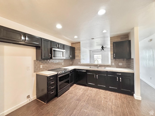 1614 W Eisenhower Way, Salt Lake City, UT 84104 - kitchen featuring stainless steel appliances, light countertops, backsplash, light wood finished floors, and a sink