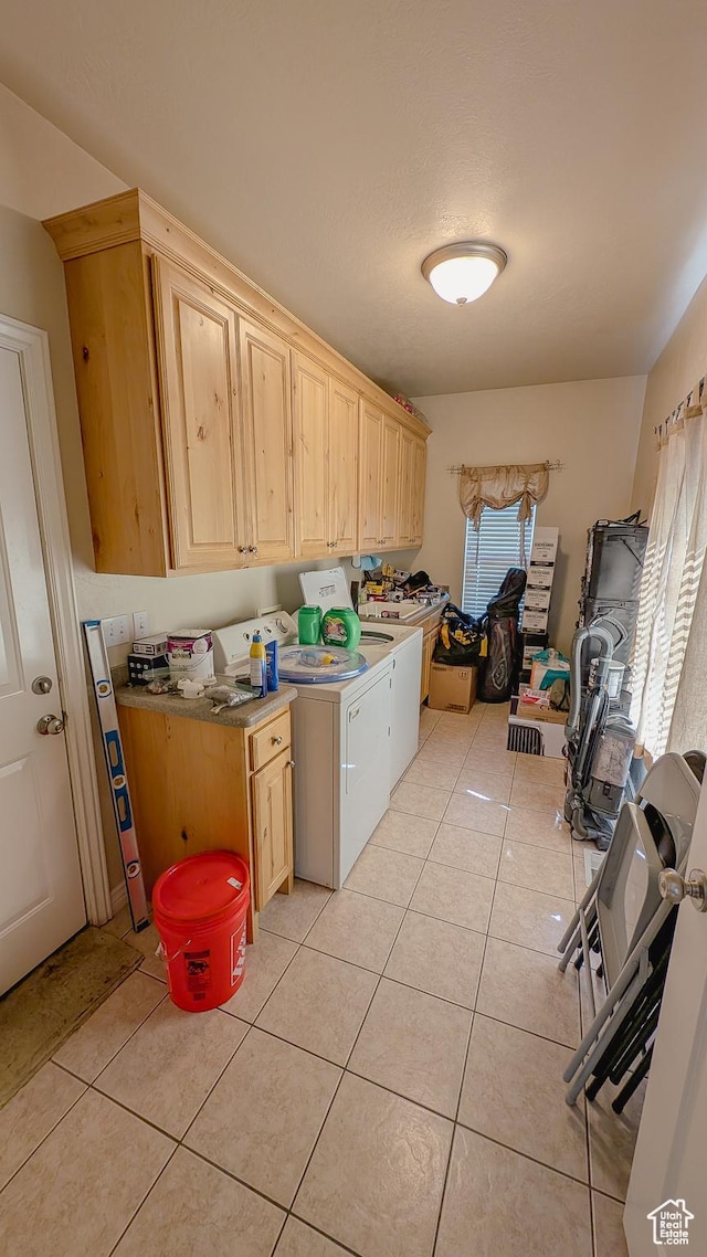 laundry room with light tile patterned flooring, cabinet space, and independent washer and dryer