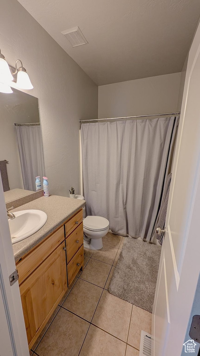 bathroom with toilet, visible vents, vanity, and tile patterned flooring