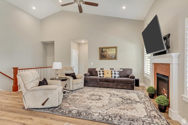 living area featuring recessed lighting, wood finished floors, a ceiling fan, and a glass covered fireplace