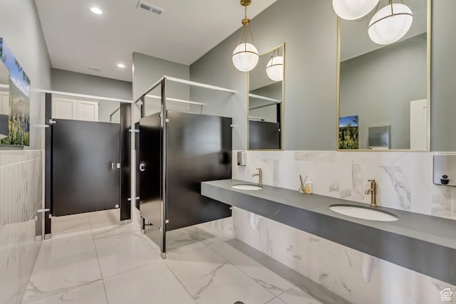 bathroom with a sink, recessed lighting, marble finish floor, and visible vents