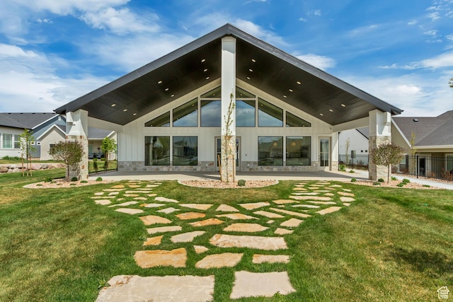 rear view of property featuring a lawn and a patio area