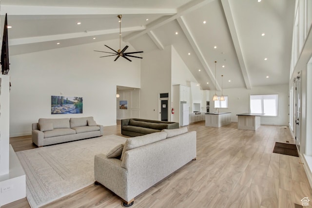 living room featuring high vaulted ceiling, beamed ceiling, light wood-style floors, and recessed lighting