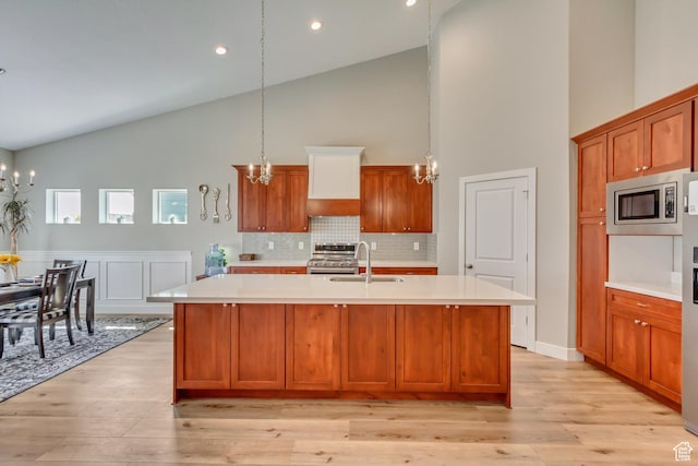 kitchen featuring appliances with stainless steel finishes, light countertops, high vaulted ceiling, and a notable chandelier