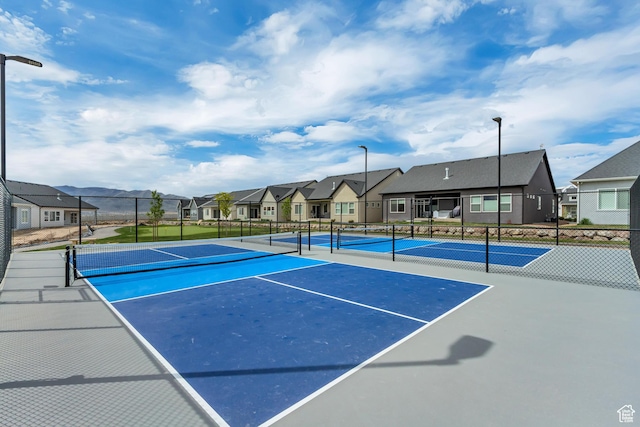 view of sport court featuring fence and a residential view