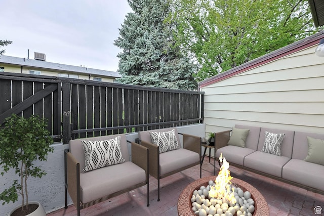 view of patio featuring an outdoor living space with a fire pit and fence