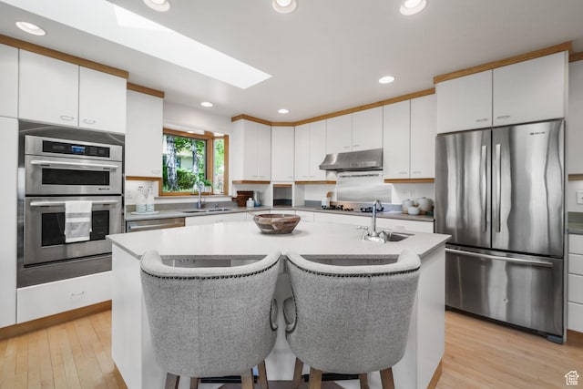 813 N Northview Dr E, Salt Lake City, UT 84103 - kitchen with stainless steel appliances, an island with sink, under cabinet range hood, and a sink