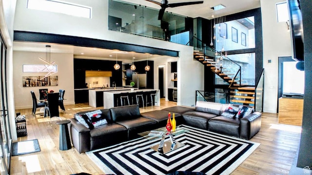 13327 S Bullitt Ln, Draper, UT 84020 - living area with a towering ceiling, stairs, and light wood-style floors