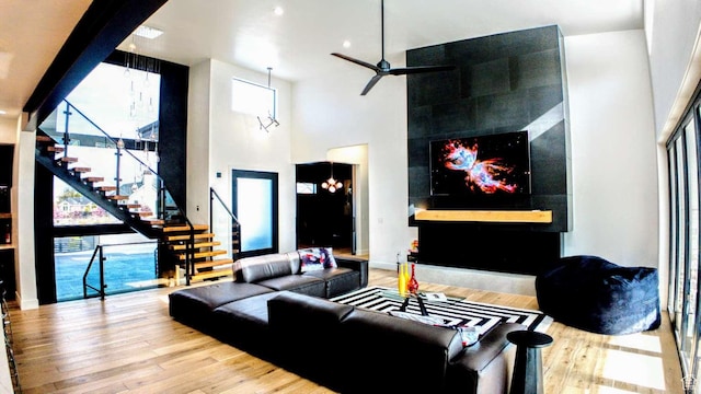 13327 S Bullitt Ln, Draper, UT 84020 - living area with a tile fireplace, wood finished floors, a high ceiling, and stairs