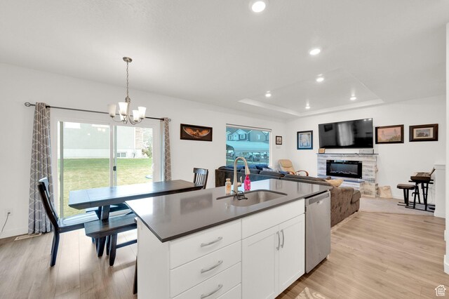 1131 S Red Cliff Dr, Santaquin, UT 84655 - kitchen with a sink, stainless steel dishwasher, light wood-type flooring, and a stone fireplace