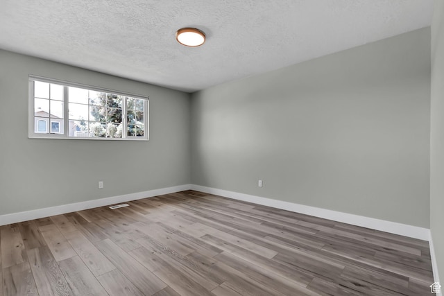 3502 W 8350 S, West Jordan, UT 84088 - unfurnished room featuring baseboards, visible vents, wood finished floors, and a textured ceiling