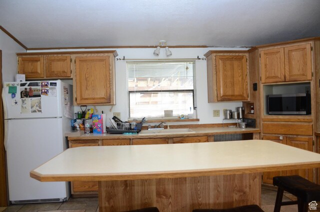 645 N 600 E, Hyrum, UT 84319 - kitchen featuring stainless steel microwave, a sink, a kitchen bar, light countertops, and freestanding refrigerator