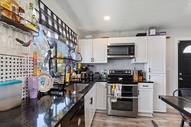 3902 W 4955 S, Taylorsville, UT 84129 - kitchen featuring light wood-style flooring, a sink, white cabinetry, and stainless steel appliances
