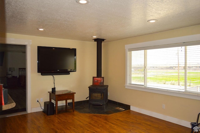 5859 E Ashley Creek Rd S, Vernal, UT 84078 - living area featuring wood finished floors, a textured ceiling, a wood stove, baseboards, and recessed lighting