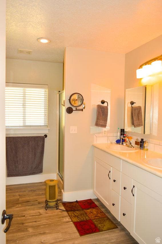 5859 E Ashley Creek Rd S, Vernal, UT 84078 - full bath featuring double vanity, a textured ceiling, a shower with shower door, wood finished floors, and baseboards