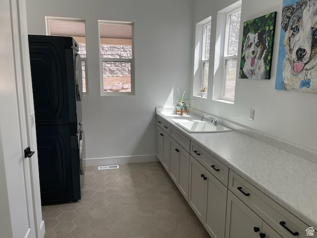 889 S Winter Ln, North Salt Lake, UT 84054 - bathroom featuring plenty of natural light, stacked washing maching and dryer, tile patterned flooring, and vanity