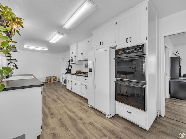 295 S 200 W, Delta, UT 84624 - kitchen with white appliances, white cabinets, dark countertops, and a sink