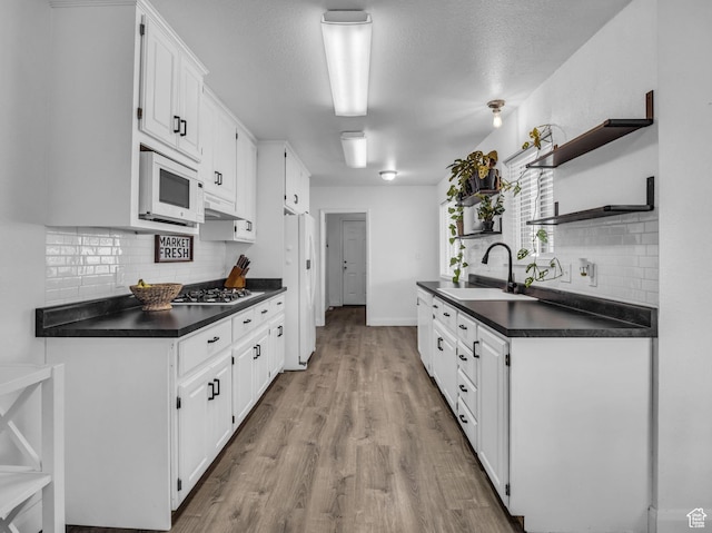 295 S 200 W, Delta, UT 84624 - kitchen featuring white appliances, open shelves, dark countertops, and a sink