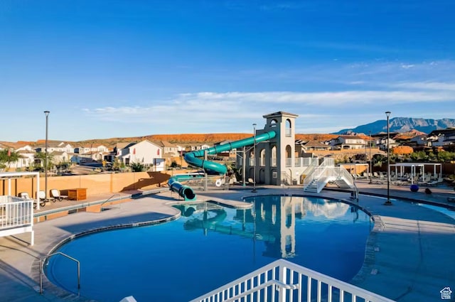 1427 N Rustico Dr, Washington, UT 84780 - community pool featuring a water slide, a mountain view, a residential view, and a patio area