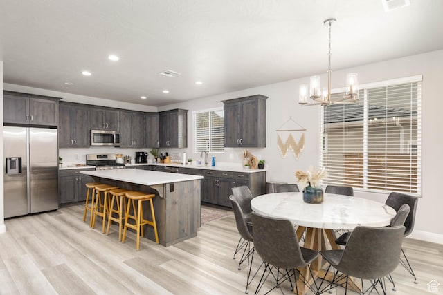 1427 N Rustico Dr, Washington, UT 84780 - kitchen with stainless steel appliances, dark brown cabinets, a chandelier, light countertops, and recessed lighting