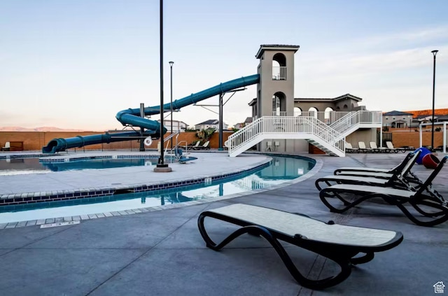 1427 N Rustico Dr, Washington, UT 84780 - community pool with a water slide, stairs, and a patio