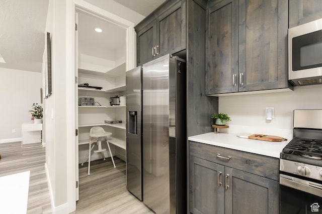 1427 N Rustico Dr, Washington, UT 84780 - kitchen featuring stainless steel appliances, light countertops, light wood-style floors, dark brown cabinetry, and recessed lighting