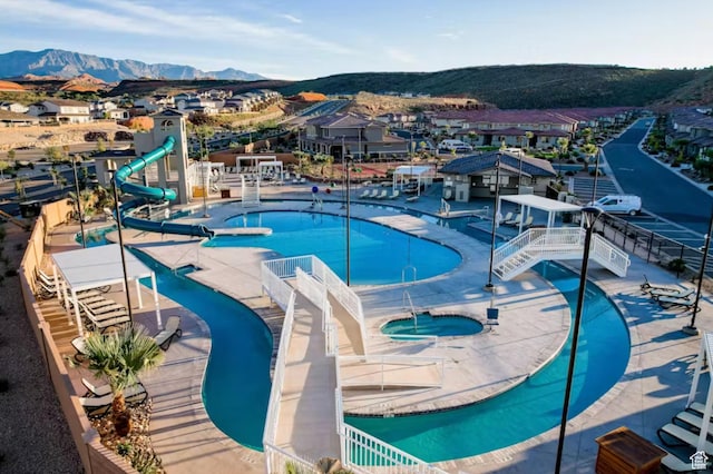 1427 N Rustico Dr, Washington, UT 84780 - community pool featuring a water slide, a hot tub, a mountain view, and a residential view
