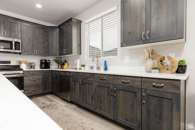 1427 N Rustico Dr, Washington, UT 84780 - kitchen featuring appliances with stainless steel finishes, dark brown cabinetry, light wood-type flooring, light countertops, and recessed lighting