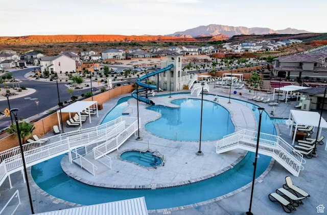 1427 N Rustico Dr, Washington, UT 84780 - community pool featuring a water slide, a community hot tub, a mountain view, a residential view, and fence