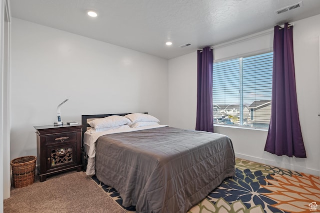 carpeted bedroom featuring baseboards, visible vents, and recessed lighting