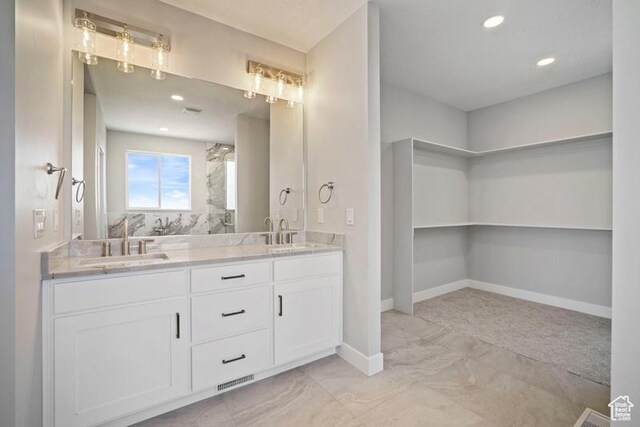 2275 E Meadowlark Ln N, North Logan, UT 84341 - full bathroom with double vanity, baseboards, marble finish floor, and a sink