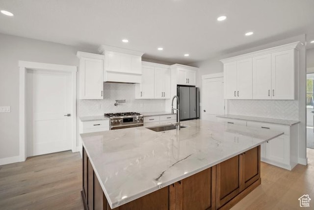 2275 E Meadowlark Ln N, North Logan, UT 84341 - kitchen featuring a sink, light wood-style flooring, stainless steel appliances, and decorative backsplash