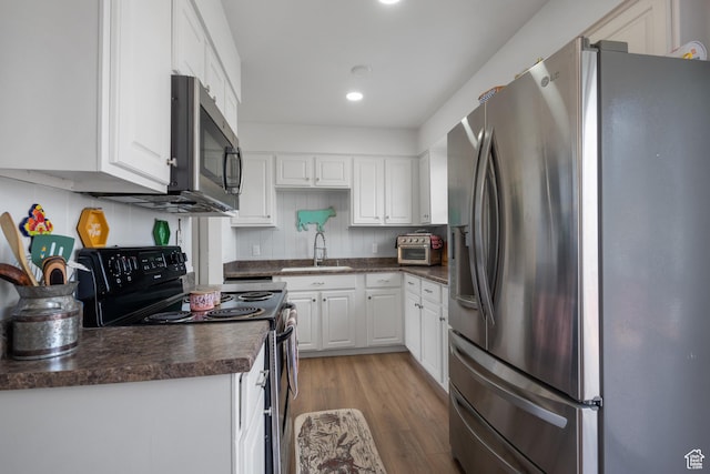 501 Valley View Dr, Tooele, UT 84074 - kitchen with white cabinets, stainless steel appliances, dark countertops, and a sink