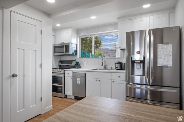 501 Valley View Dr, Tooele, UT 84074 - kitchen featuring white cabinetry, a sink, appliances with stainless steel finishes, light wood-type flooring, and recessed lighting