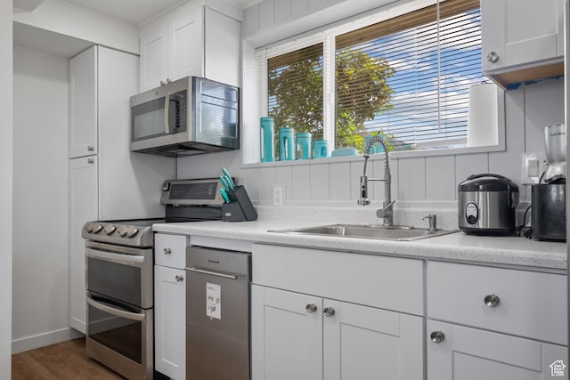 501 Valley View Dr, Tooele, UT 84074 - kitchen with appliances with stainless steel finishes, white cabinetry, light countertops, and a sink