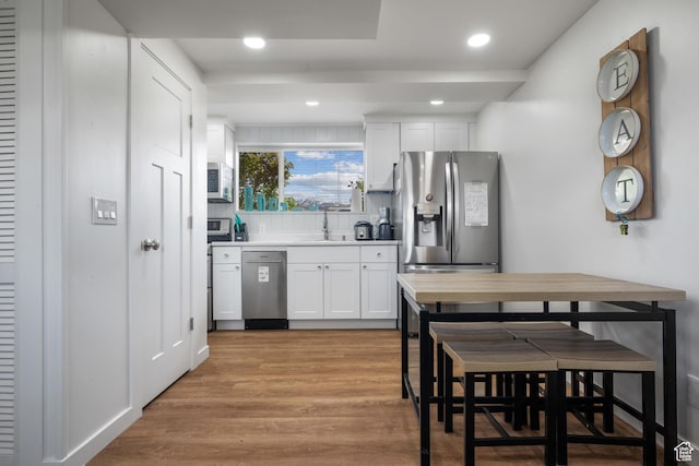 501 Valley View Dr, Tooele, UT 84074 - kitchen with white cabinetry, light wood-style flooring, a sink, appliances with stainless steel finishes, and recessed lighting