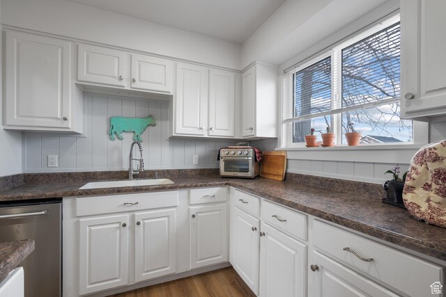501 Valley View Dr, Tooele, UT 84074 - kitchen with a toaster, dark countertops, dishwasher, a sink, and white cabinetry