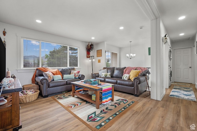 501 Valley View Dr, Tooele, UT 84074 - living room with recessed lighting, an inviting chandelier, stacked washer and clothes dryer, and light wood-style floors