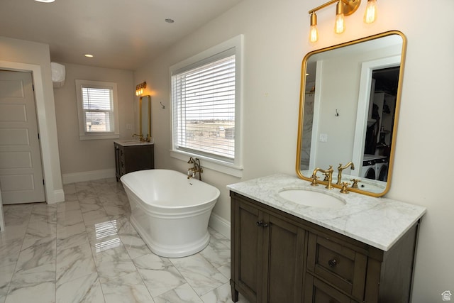 815 S Annabella Rd, Richfield, UT 84701 - full bathroom featuring a sink, a freestanding tub, marble finish floor, two vanities, and baseboards