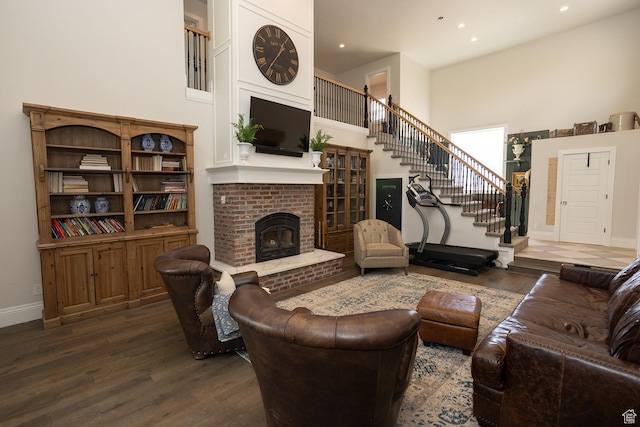 815 S Annabella Rd, Richfield, UT 84701 - living area featuring a fireplace, dark wood-type flooring, stairs, baseboards, and a towering ceiling