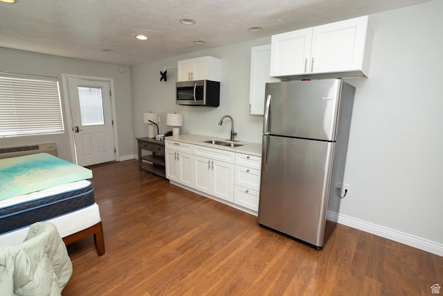 815 S Annabella Rd, Richfield, UT 84701 - kitchen with white cabinets, a sink, appliances with stainless steel finishes, baseboards, and wood finished floors