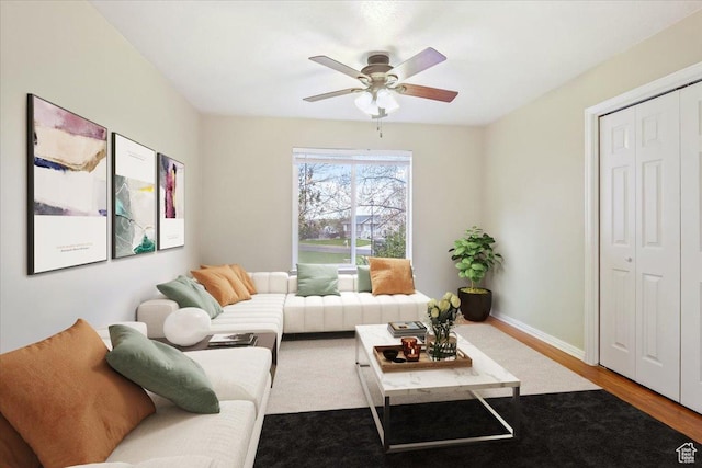 living area featuring a ceiling fan, wood finished floors, and baseboards